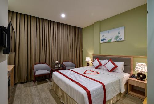 a hotel room with a bed and a television at Hue My Hotel in Ho Chi Minh City