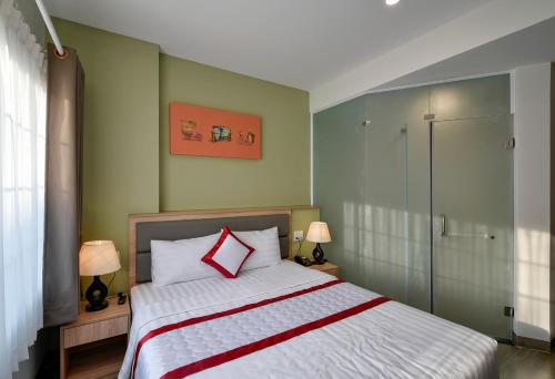 a bedroom with a bed and a glass shower at Hue My Hotel in Ho Chi Minh City
