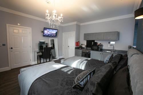 a living room with a couch and a kitchen at Apartments at Number 82 The Unthank in Norwich