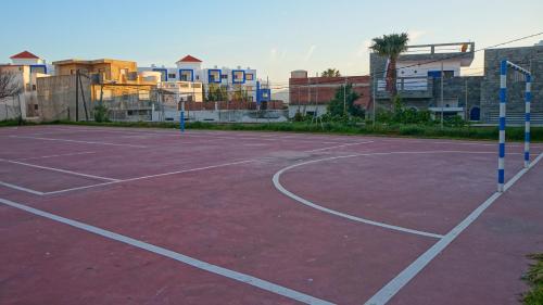 an empty tennis court with buildings in the background at Mirador Golf Appart-hotel in Cabo Negro