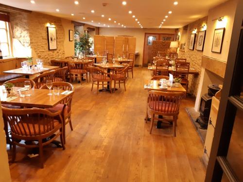 ウェルズにあるThe Crown at Wells, Somersetの木製のテーブルと椅子が備わる空きレストランです。