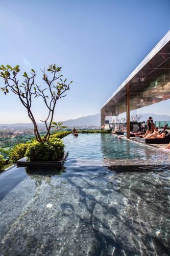 a infinity pool with a tree on top of a building at The Astra Condo City Center Chiang Mai-Apartment rental in Chiang Mai