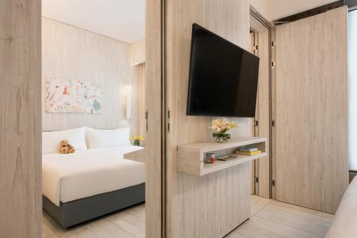 a bedroom with a bed and a flat screen tv at Village Hotel Sentosa by Far East Hospitality in Singapore