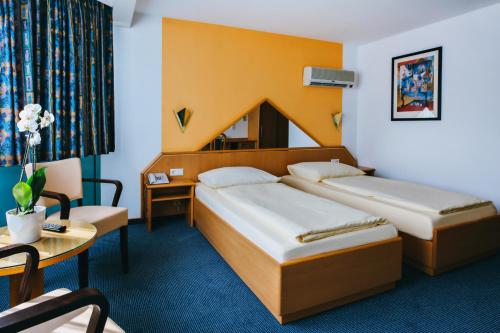 Habitación de hotel con 2 camas y mesa en Hotel Central, en Weil am Rhein