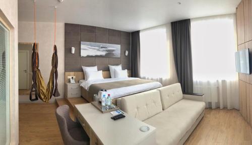 um quarto de hotel com uma cama e um sofá em F911 Яхт Клуб Отель em Ecaterimburgo