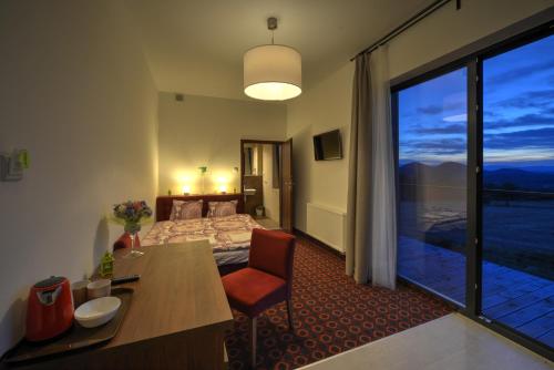 ein Hotelzimmer mit einem Bett und einem großen Fenster in der Unterkunft Browar Miedzianka in Miedzianka