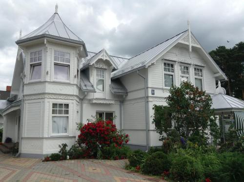 a large white house with at Naiza Guesthouse and Apartments in Jūrmala
