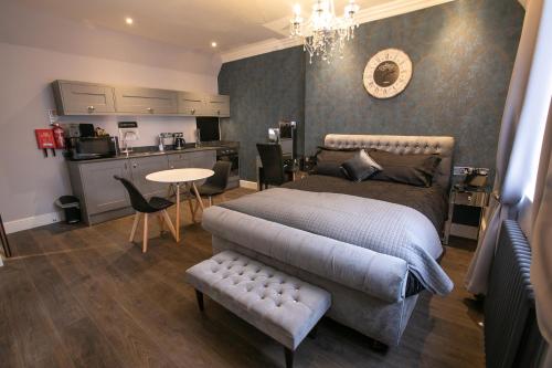 a bedroom with a bed and a table and a kitchen at Apartments at Number 82 The Unthank in Norwich