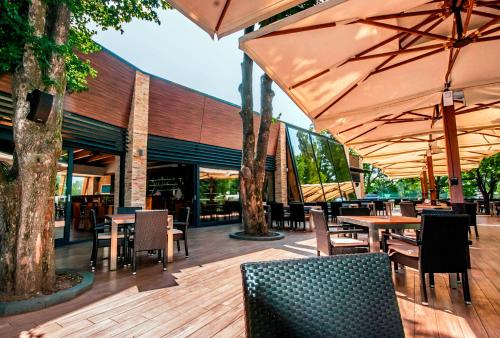 an outdoor patio with tables and chairs and umbrellas at Villas and apartments Oaza in Sarajevo
