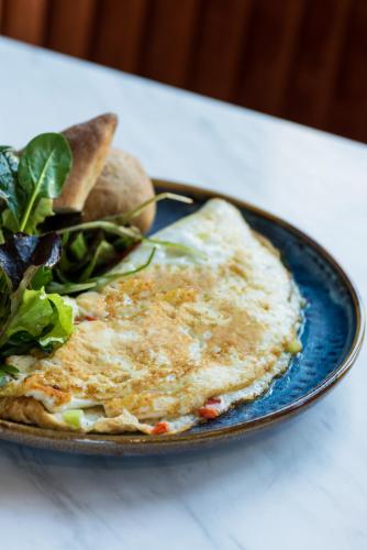 a plate of food with an egg and a salad at Capsis Bristol Boutique Hotel in Thessaloniki