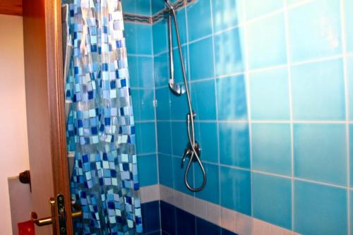 a blue tiled shower with a shower head at Casa THE NEST - Il Nido sul Mare in Badesi
