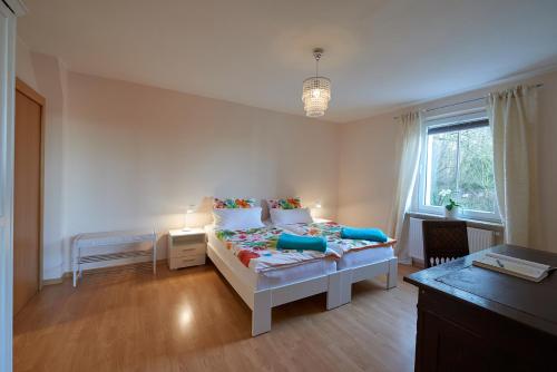 a white bedroom with a bed and a window at Ferienwohnung am Benther Berg in Gehrden