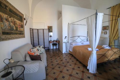a bedroom with a bed and a couch at Palazzo Barba in Gallipoli