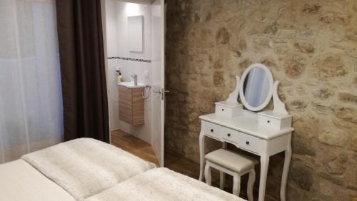 een badkamer met een bed, een wastafel en een spiegel bij Can Teixidor in Besalú