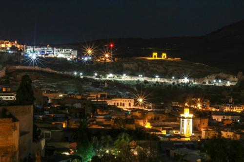 a view of a city at night at Riad Fes Nass Zmane in Fès
