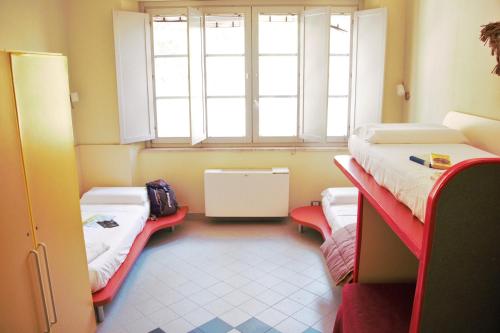 a room with two beds and a window at Ostello La Miniera in Massa Marittima