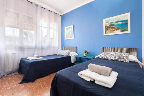 2 camas en una habitación con paredes azules en Fonda Chavarria, en Sant Joan Despí