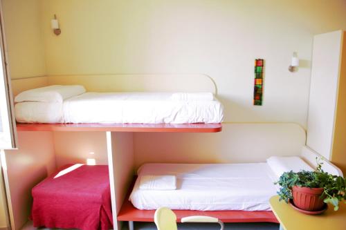 two bunk beds in a small room with a table at Ostello La Miniera in Massa Marittima