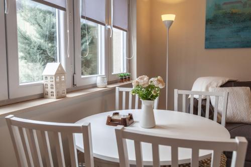 諾維薩德的住宿－DC Executive Homes，一张带椅子的白色桌子和一个花瓶