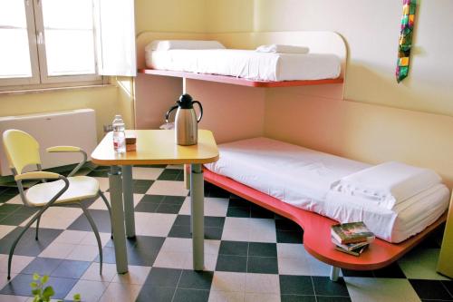 a small room with a bunk bed and a table at Ostello La Miniera in Massa Marittima