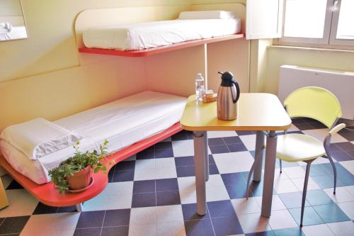a small room with a bunk bed and a table at Ostello La Miniera in Massa Marittima