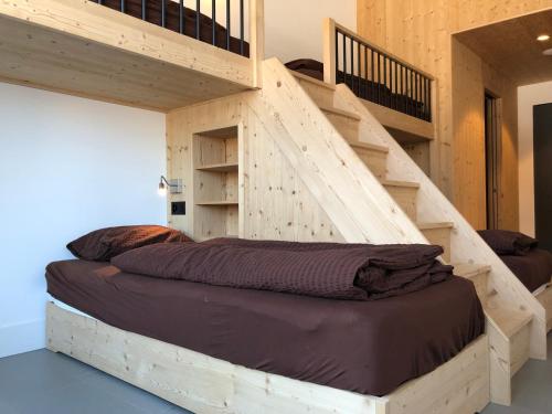 Etagenbett in einem Zimmer mit einer Treppe in der Unterkunft Catrina Hostel in Disentis
