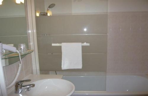 a white bathroom with a sink and a shower at Auberge De Bourgogne in Tonnerre