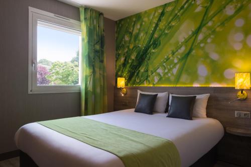 a bedroom with a large bed and a window at The Originals City, Hôtel Le Garden, Tours Sud (Inter-Hotel) in Chambray-lès-Tours