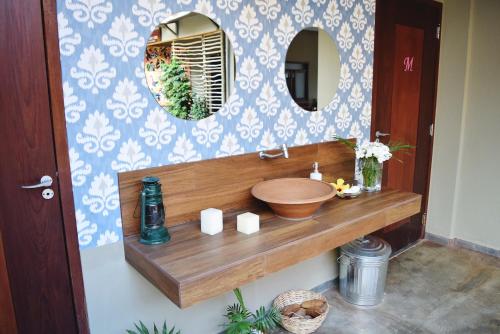 La salle de bains est pourvue d'un lavabo en bois et d'un miroir. dans l'établissement Pousada Só Alegria, à São Miguel do Gostoso