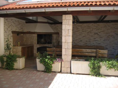 an outdoor patio with a bench and a fireplace at Apartments Capic in Baška