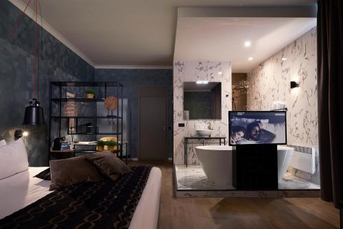 a bathroom with a tub and a tv in a room at Hotel Zuid in Genk