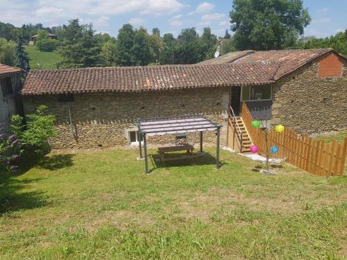 a picnic table in front of a stone house at Cier De Riviere "les Ours" in Cier-de-Rivière
