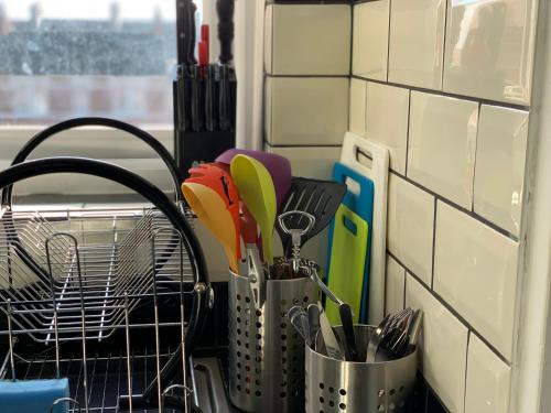 a kitchen counter with a dish rack with utensils at Eskdaill Place Apartment in Kettering