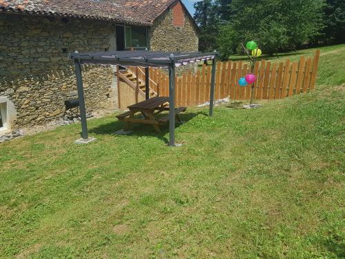 a picnic table in a yard next to a fence at Cier De Riviere "les Ours" in Cier-de-Rivière