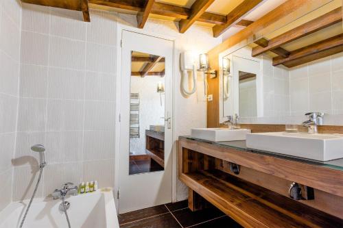 a bathroom with two sinks and a mirror at Madame Vacances Hôtel Ibiza in Les Deux Alpes