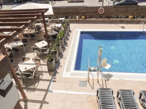 an overhead view of a swimming pool with tables and chairs at Hotel Cesar Augustus in Cambrils