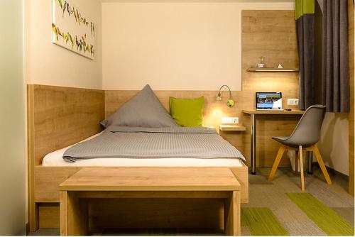 Schlafzimmer mit einem Bett, einem Schreibtisch und einem Stuhl in der Unterkunft Landgasthof Zur Sonne in Fünfstetten