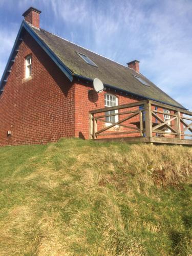 a red brick house on top of a grassy hill at The Gardener's House in Covington