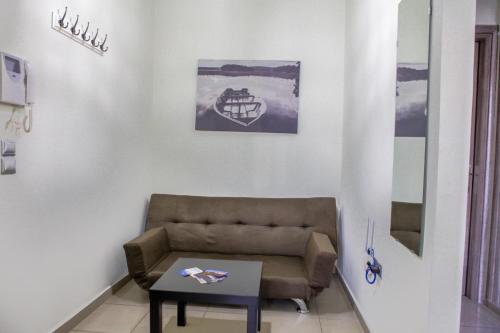 a living room with a couch and a table at Lak Peristeri Homes 50m from metro station in Athens