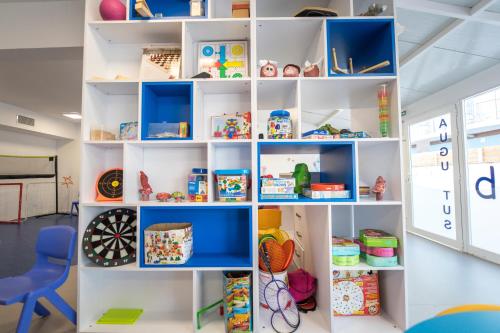 a room with white shelves filled with toys at Hotel Cesar Augustus in Cambrils