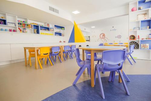 a classroom with tables and colorful chairs at Hotel Cesar Augustus in Cambrils