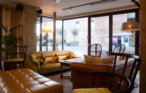hol z kanapą, stołem i krzesłami w obiekcie Bermondsey Square Hotel - A Bespoke Hotel w Londynie
