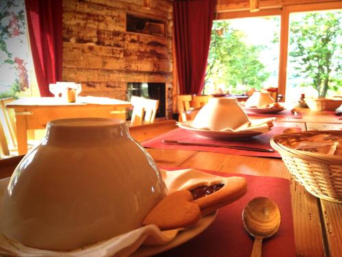 a table with a vase and two cookies on a plate at Rifugio Serot in Roncegno