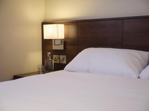 a white bed with a white comforter and pillows at Marlin Waterloo in London