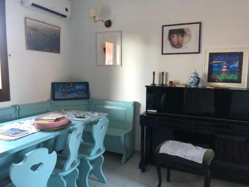 a living room with a table and a piano at La Lantana Nuova in Flumini di Quartu