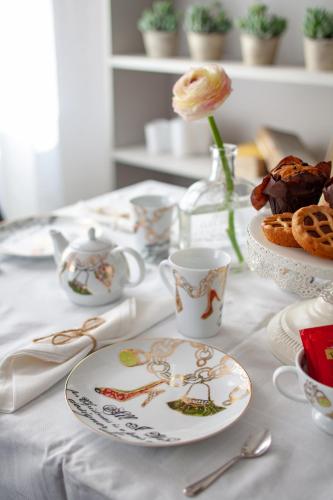 a table with plates and cups and a flower on it at Laguna Boutique Apartments in Mestre