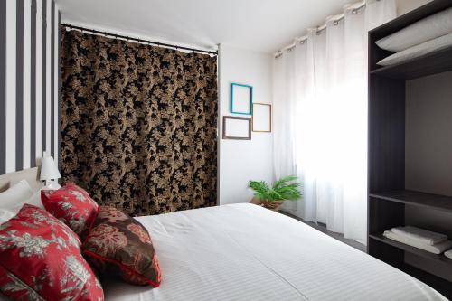 a bedroom with a white bed with red pillows at Laguna Boutique Apartments in Mestre