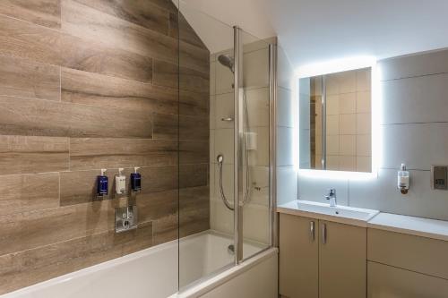 a bathroom with a shower with a tub and a sink at The Gamekeeper's Inn in Skipton