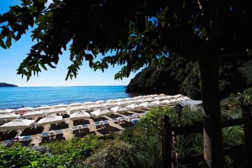 a row of umbrellas on a beach with the ocean at Grand Hotel Il Ninfeo in Gaeta