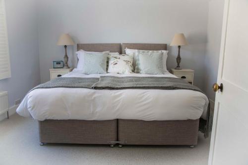 a bedroom with a large bed with white sheets and pillows at Spencer House in Sandwich